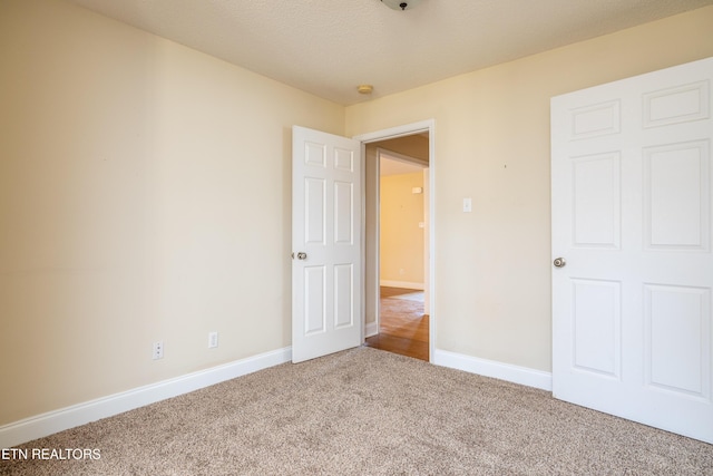 unfurnished bedroom with carpet and a textured ceiling