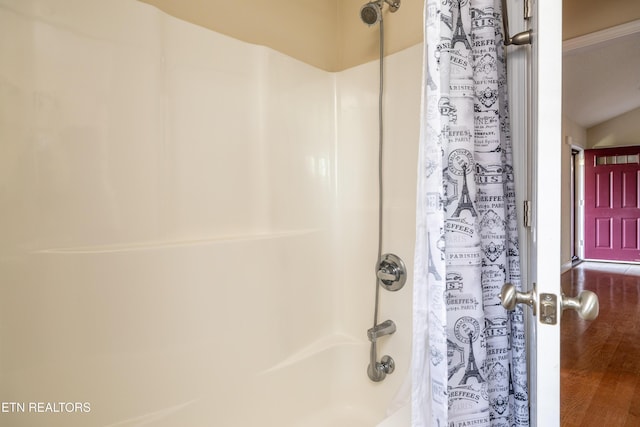 bathroom featuring wood-type flooring and shower / bath combo with shower curtain