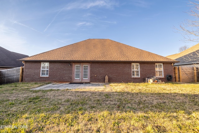 back of property with a yard and a patio