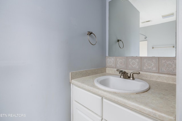 bathroom with tasteful backsplash and vanity