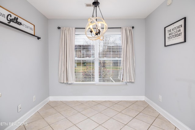 unfurnished dining area with a chandelier and light tile patterned floors