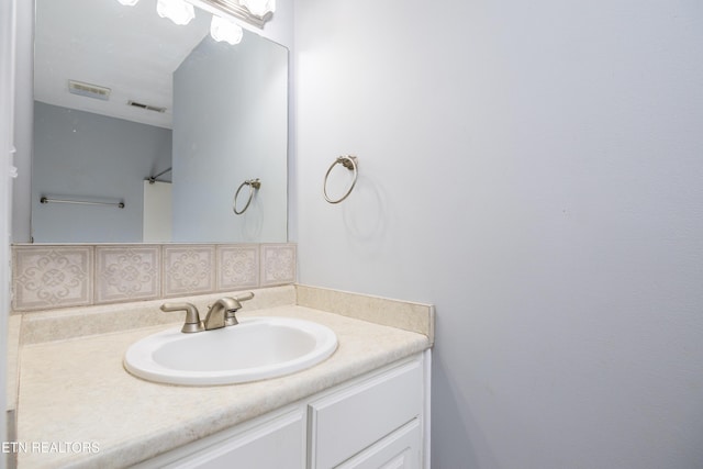 bathroom featuring vanity and backsplash