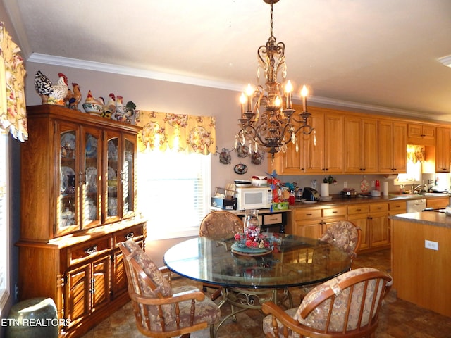 dining space featuring ornamental molding, sink, and a chandelier