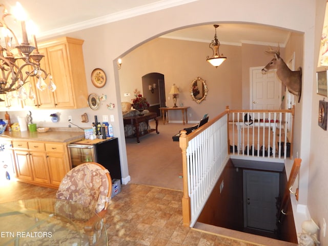 kitchen with pendant lighting, light colored carpet, ornamental molding, and light brown cabinetry