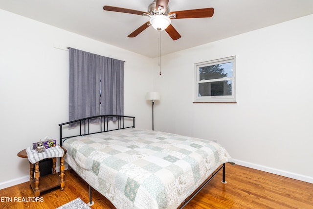 bedroom with ceiling fan and hardwood / wood-style flooring