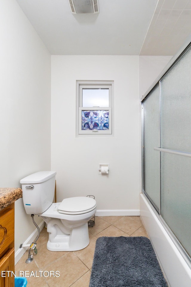 full bathroom with tile patterned floors, vanity, bath / shower combo with glass door, and toilet