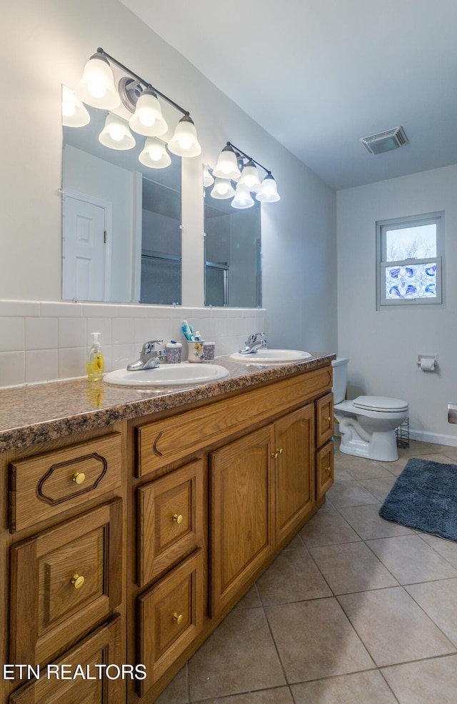 bathroom with toilet, vanity, tasteful backsplash, and tile patterned floors