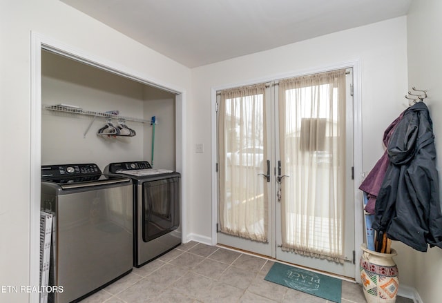 laundry room with washer and clothes dryer and light tile patterned flooring