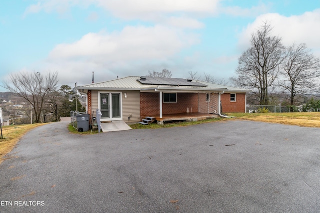 view of front of house with solar panels and a deck