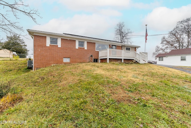 back of house with a wooden deck and a yard