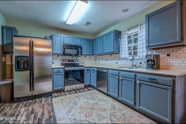 kitchen with decorative backsplash, sink, stainless steel appliances, and dark hardwood / wood-style floors