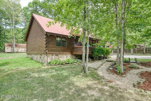 view of property exterior with a lawn, a storage shed, and a wooden deck