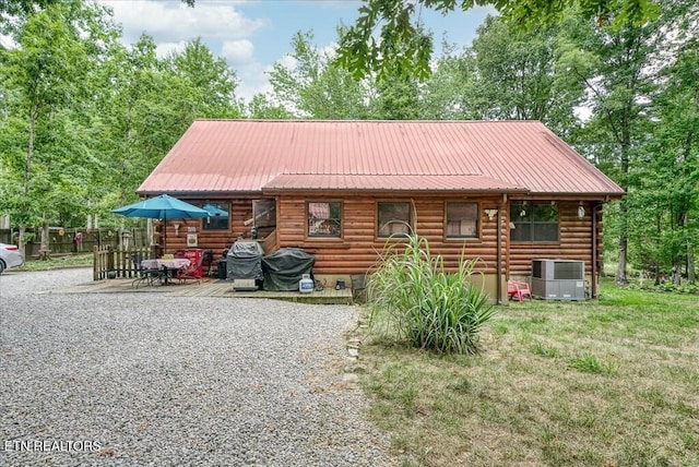 log home with central air condition unit and a front yard