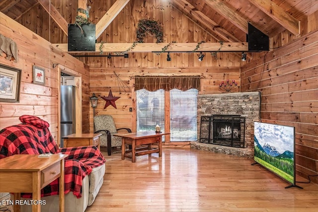 living area featuring hardwood / wood-style floors, wood walls, wooden ceiling, high vaulted ceiling, and beam ceiling