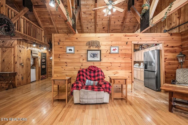 living room featuring beamed ceiling, light wood-type flooring, and wooden ceiling