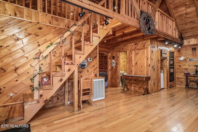 interior space with wood ceiling, wood walls, wood-type flooring, and lofted ceiling