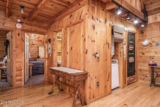 hall with beam ceiling, wood walls, light hardwood / wood-style flooring, and wooden ceiling