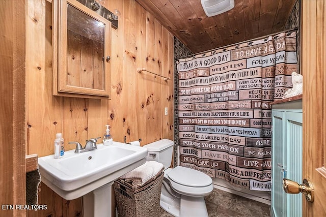 bathroom featuring sink, wooden ceiling, walk in shower, toilet, and wooden walls