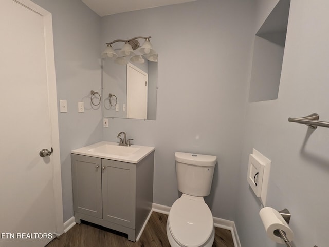 bathroom featuring wood-type flooring, vanity, and toilet