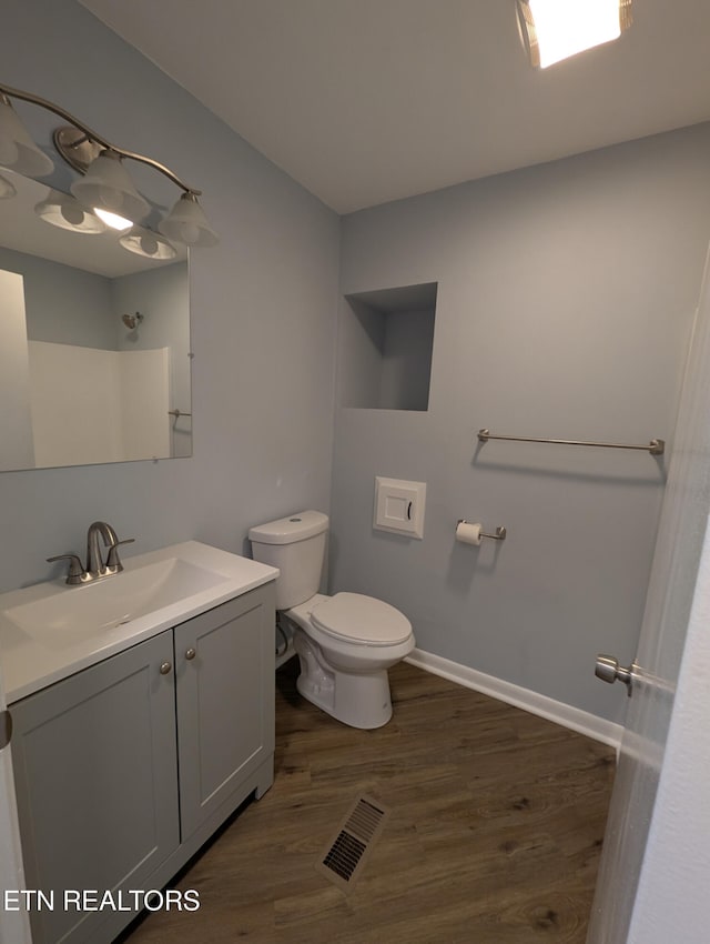 bathroom featuring vanity, wood-type flooring, and toilet