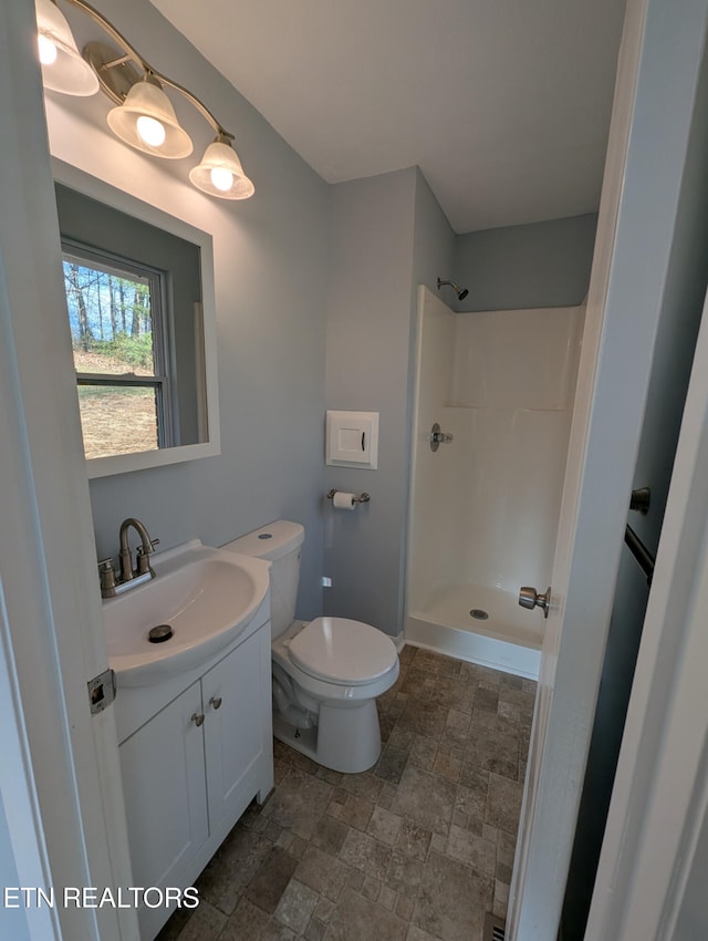 bathroom with vanity, toilet, and walk in shower