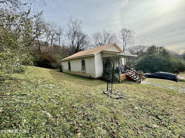 view of property exterior with a lawn and a porch