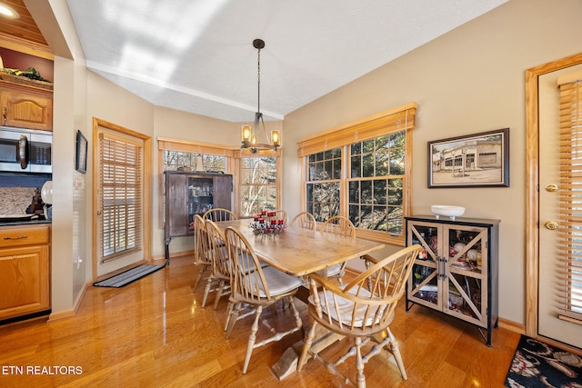 dining room with light hardwood / wood-style flooring and a chandelier