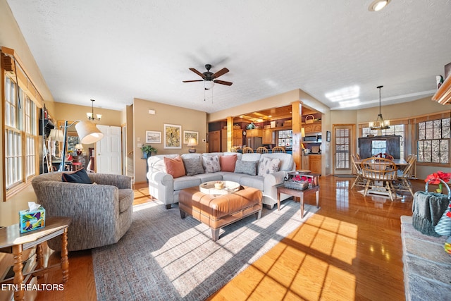 living room featuring wood-type flooring, a textured ceiling, and ceiling fan