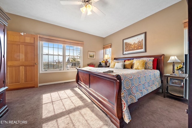 bedroom with ceiling fan, carpet floors, and a textured ceiling