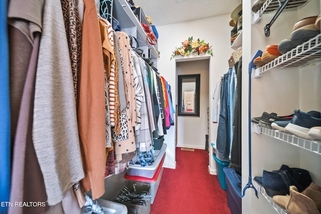 walk in closet featuring carpet flooring