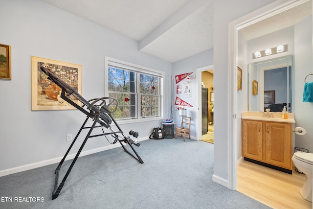 workout room with light carpet, sink, and a textured ceiling