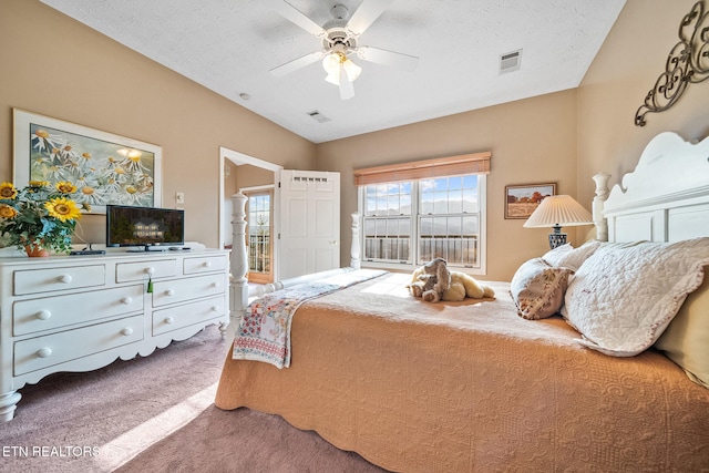 carpeted bedroom with ceiling fan and a textured ceiling