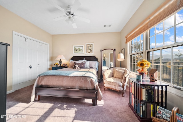 bedroom featuring multiple windows, ceiling fan, a closet, and carpet floors