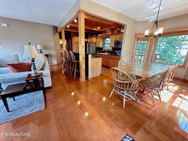 1132 E Foothills Dr, Gatlinburg, TN 37738 - dining space featuring light wood-type flooring, a textured ceiling, a chandelier, and baseboards
