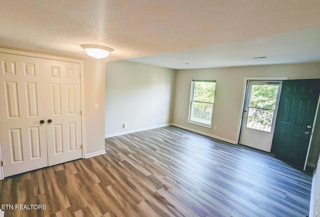 empty room with hardwood / wood-style flooring and a textured ceiling