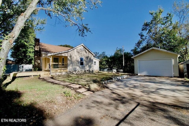 view of side of property featuring a garage, covered porch, and an outdoor structure