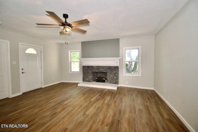 unfurnished living room featuring dark hardwood / wood-style floors, ceiling fan, and a fireplace