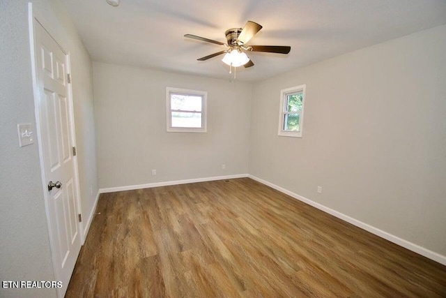 spare room featuring a wealth of natural light, light hardwood / wood-style flooring, and ceiling fan