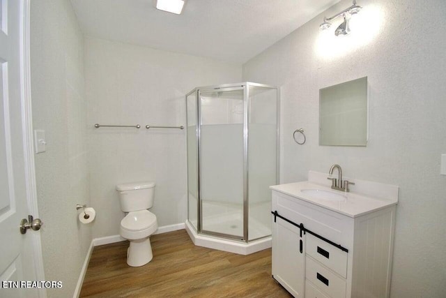 bathroom featuring toilet, hardwood / wood-style floors, vanity, and walk in shower