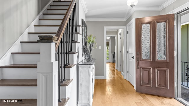 foyer featuring crown molding and light hardwood / wood-style floors