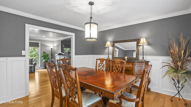 dining area featuring light hardwood / wood-style flooring and crown molding