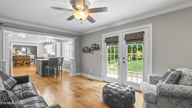 living room with french doors, light wood-type flooring, ceiling fan, and a healthy amount of sunlight