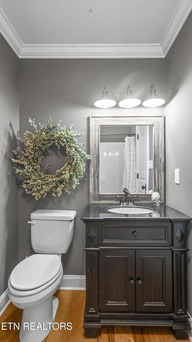 bathroom featuring hardwood / wood-style flooring, toilet, vanity, and ornamental molding