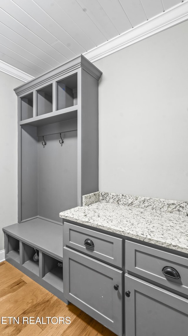 mudroom with light hardwood / wood-style floors and crown molding