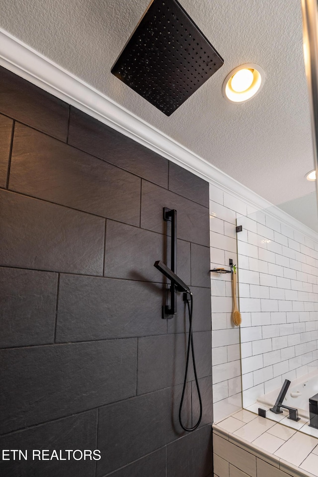 bathroom featuring tiled shower, a textured ceiling, and crown molding