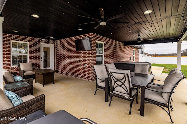 view of patio with ceiling fan, an outdoor hangout area, and a hot tub