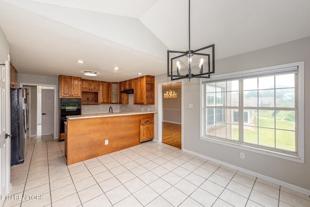 kitchen featuring open shelves, a chandelier, a peninsula, light countertops, and brown cabinetry