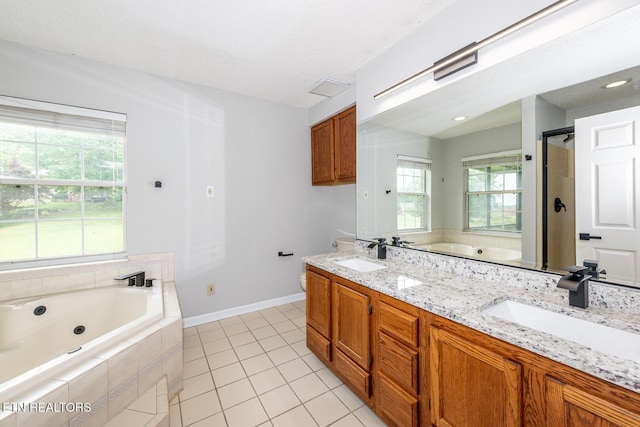 full bathroom featuring a whirlpool tub, tile patterned flooring, double vanity, and baseboards