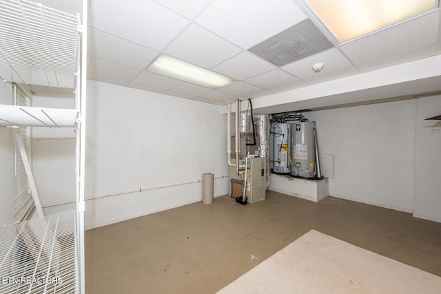 finished basement featuring water heater, heating unit, and a drop ceiling