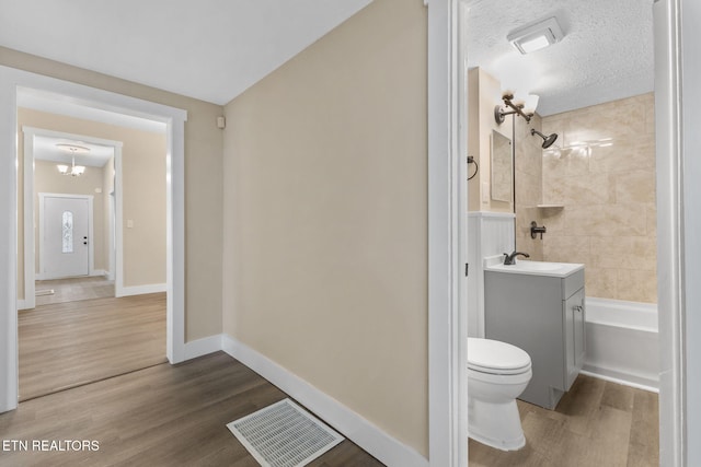 full bathroom featuring vanity, toilet, wood-type flooring, and a textured ceiling